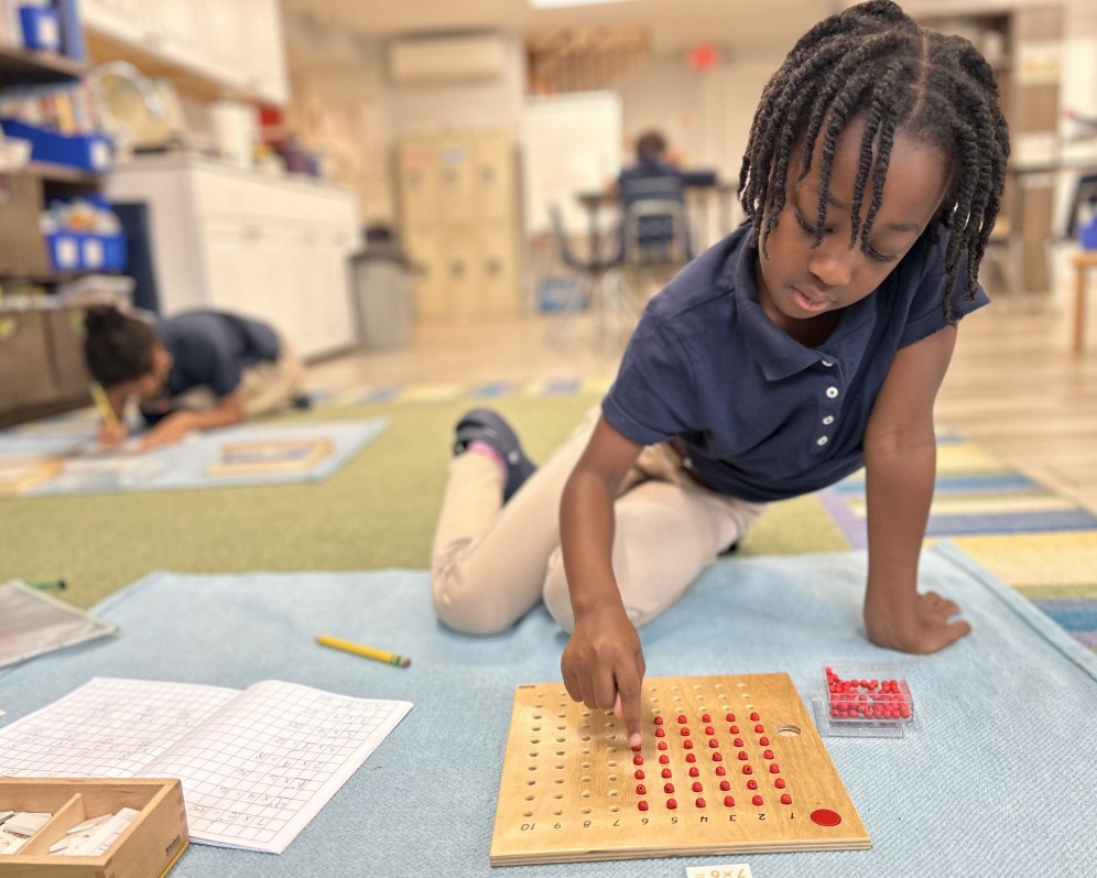 a student using the multiplication bead board