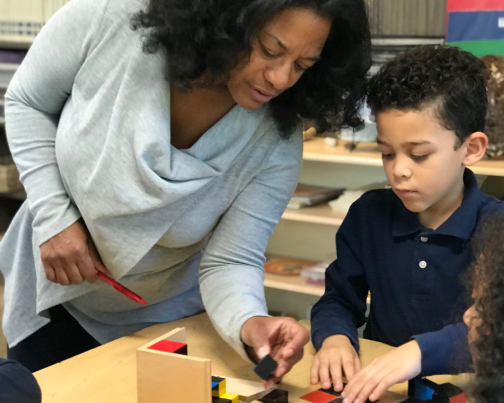 teacher and student working on trinomial cube